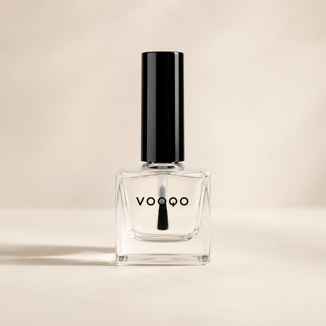 Vooqo clear Nail Top Coat in glass bottle on a warm ivory background