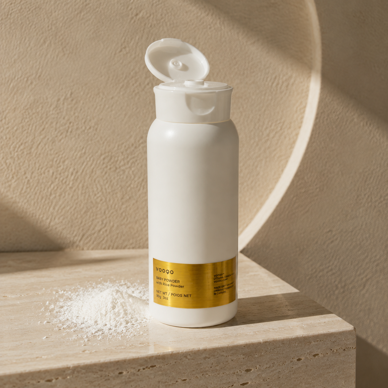 Open Vooqo Baby Powder bottle with soft rice powder texture on warm travertine