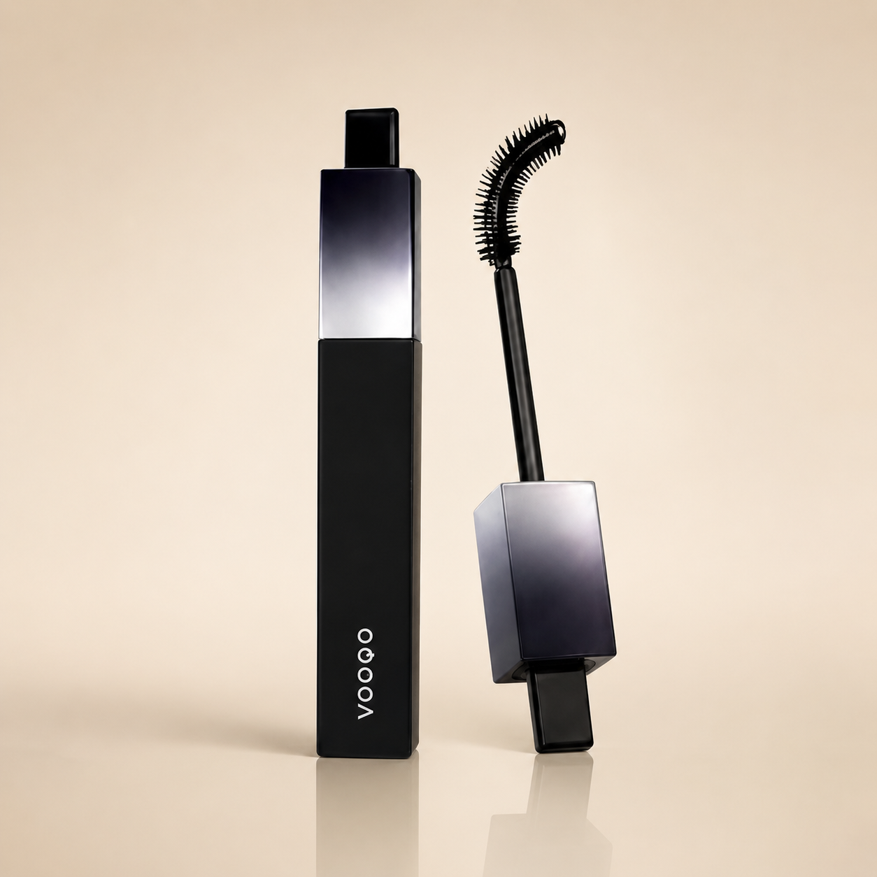 Vooqo mascara shown with its black rectangular tube and wand applicator on a warm beige studio background.